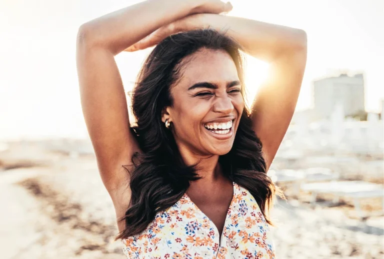 Happy young black woman smiling relaxing on the beach