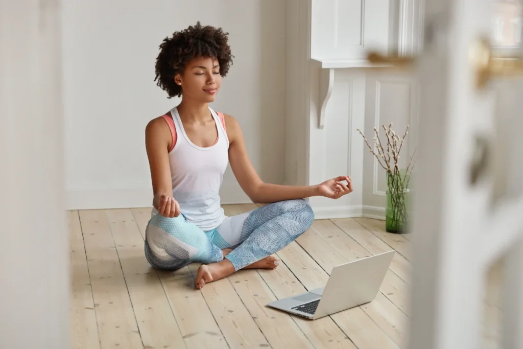 Woman meditates on floor in empty room